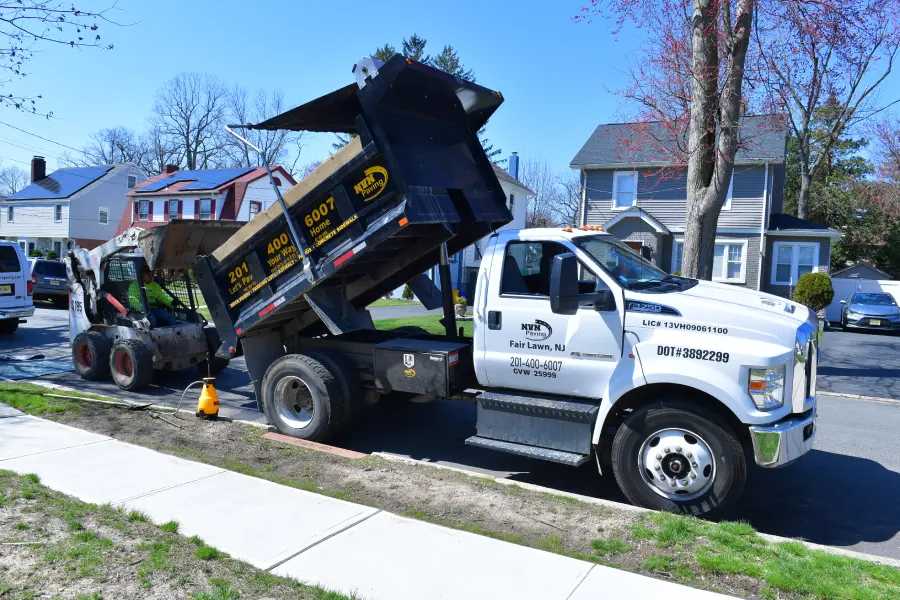 NVN Paving truck and skid steer on site for a residential paving project in Bergen County, NJ