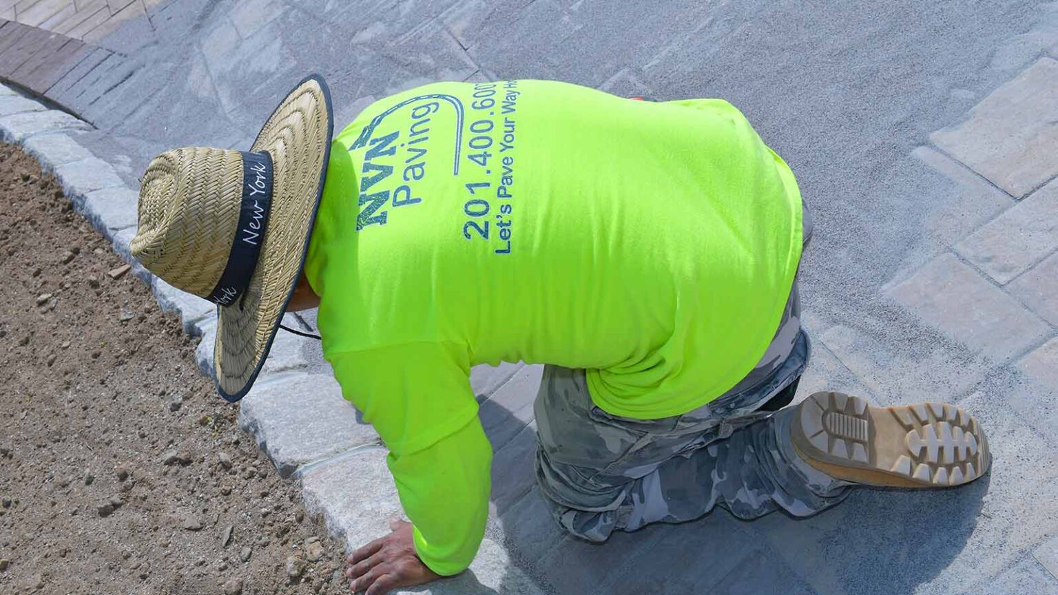 Worker from NVN Paving installing patio and driveway pavers in New Jersey, ensuring precision and quality craftsmanship.