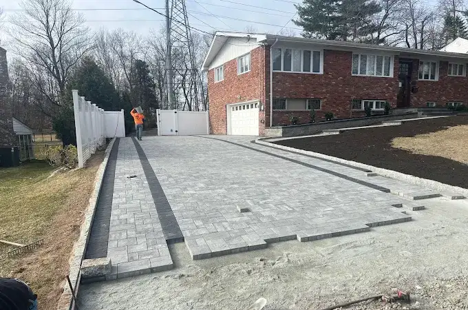 NVN Paving completing a modern paver driveway installation in New Jersey with gray interlocking stones and clean edging