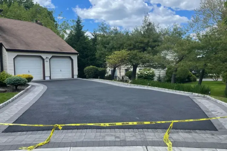 Freshly paved asphalt driveway in New Jersey home, showing durability and affordability benefits of asphalt paving.