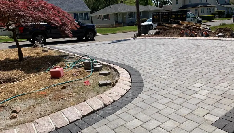 A newly installed paver driveway with decorative borders and landscaping, showcasing professional local paving expertise in Somerset County, NJ.