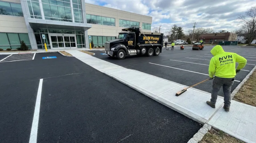NVN Paving crew finishing concrete sidewalks and asphalt parking lot paving at a commercial medical facility in Bergen County, NJ, showcasing full-service site capabilities.